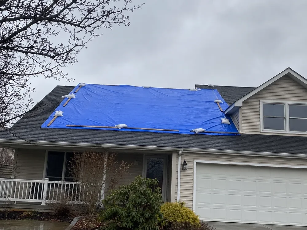 Emergency tarp protecting a roof while an insurance claim is processed